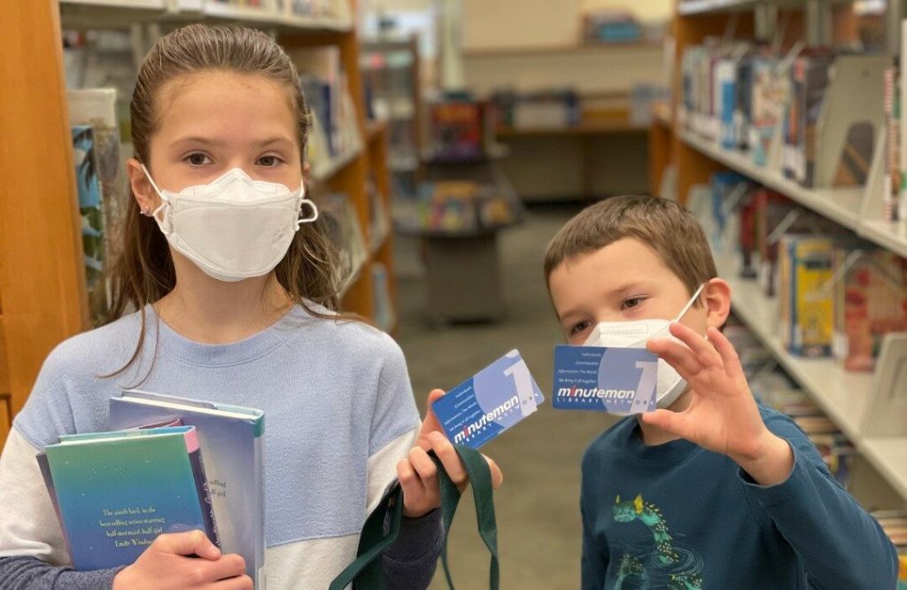 Young boy and girl holding library cards